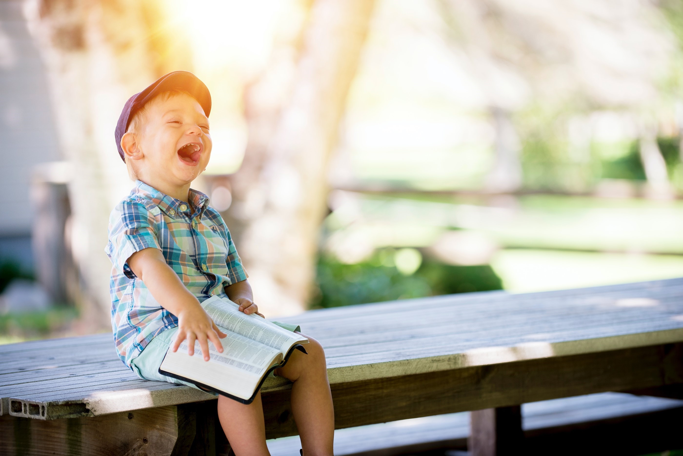 Boy laughing with a book on his knees