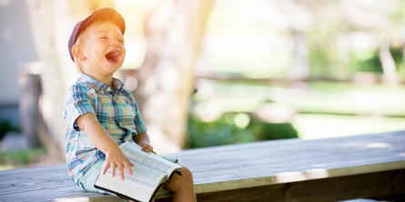 Boy laughing with a book on his knees