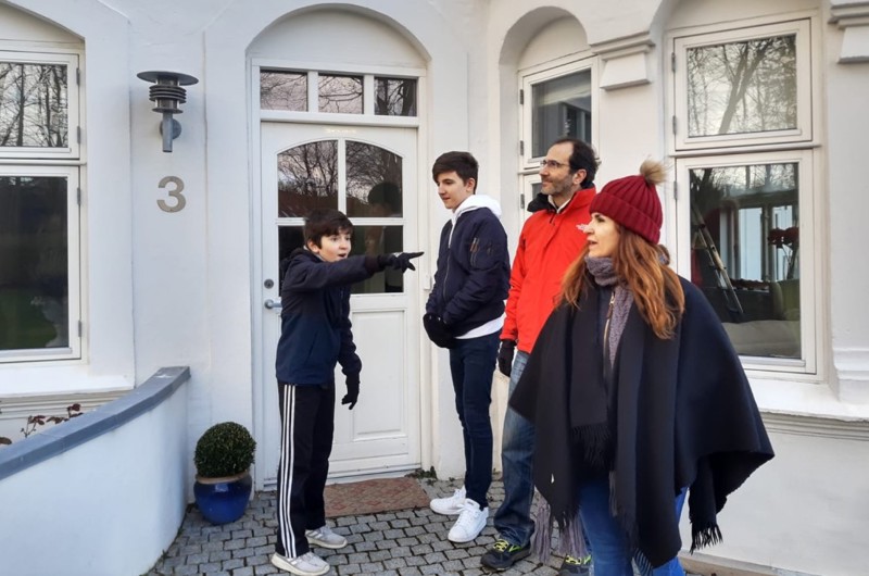 Family standing next to a house